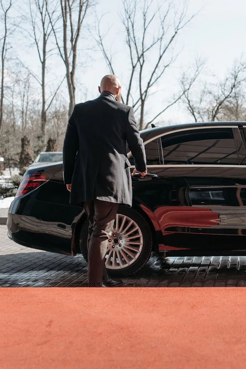 pga national resort car service pga national resort car service PGA National Resort car service Car Service Palm Beach Gardens FL: professional chauffeur waiting next to a luxury black car on PGA Boulevard.